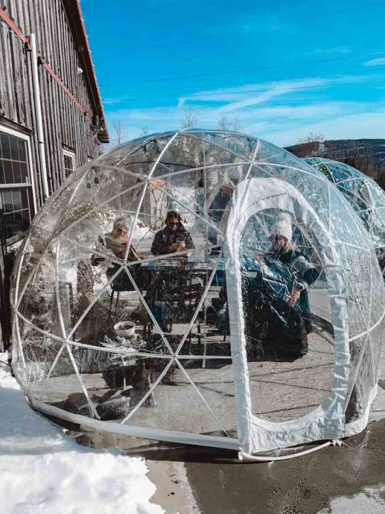 Mountain State Brewery at Deep Creek Lake, MD, with winter igloos for dining, wood-fired pizza, and ski resort views.