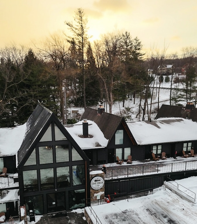 Cove Creek Inn at sunset, covered in snow, glowing with winter charm—an inviting retreat near Deep Creek Lake, Maryland.